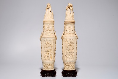 A pair of tall Chinese ivory vases and covers on wooden base, early 20th C.